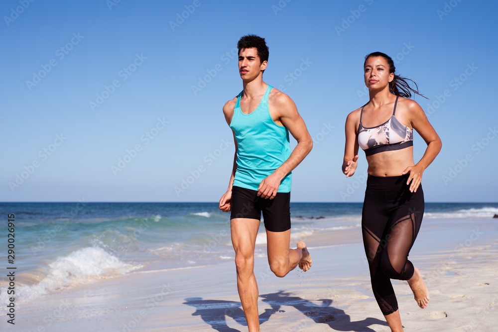 Man and woman running along the seashore Man and woman running along the seashore