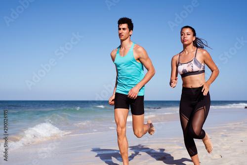 Man and woman running along the seashore