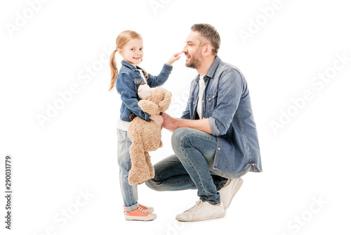 smiling dad in jeans and daughter with teddy bear isolated on white