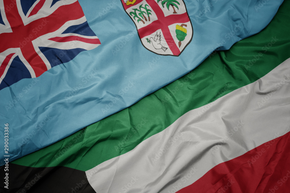 waving colorful flag of kuwait and national flag of Fiji .