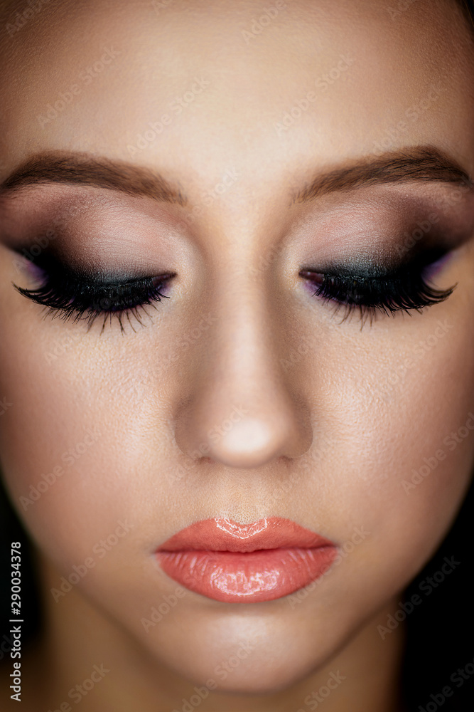 Portrait of a young woman with beautiful evening make-up on a dark background Portrait of a young woman with beautiful evening make-up on a dark background