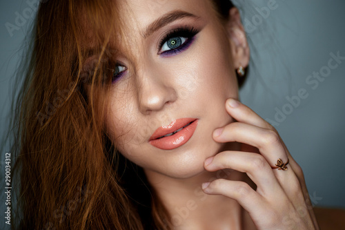 Portrait of a young woman with beautiful evening make-up on a dark background