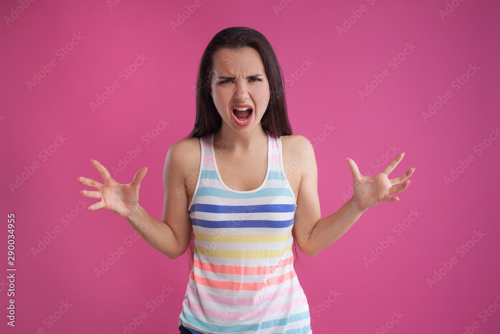 Brunette woman with long hair, dressed in colorful striped shirt, posing against pink studio background. Sincere emotions. Close-up. Brunette woman with long hair, dressed in colorful striped shirt, posing against pink studio background. Sincere emotions. Close-up.