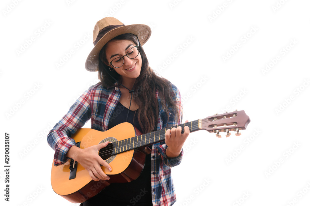 teenage girl with holding a guitar with her hand outstretched, young artist girl with her musical instrument, Dressed in plaid shirt and hat. teenage girl with holding a guitar with her hand outstretched, young artist girl with her musical instrument, Dressed in plaid shirt and hat.