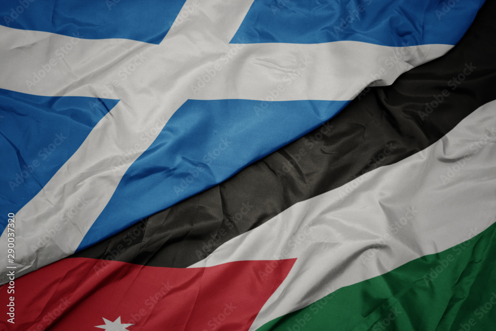 waving colorful flag of jordan and national flag of scotland.