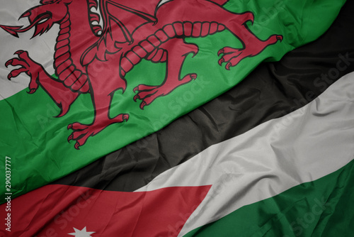 waving colorful flag of jordan and national flag of wales.