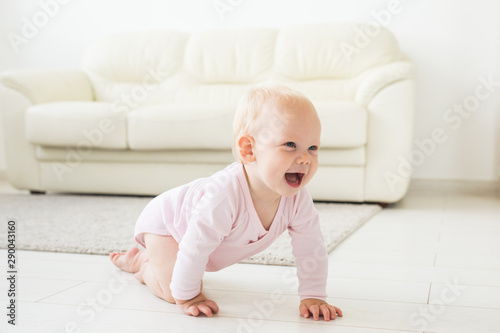 Smiling crawling baby girl at home on floor photo