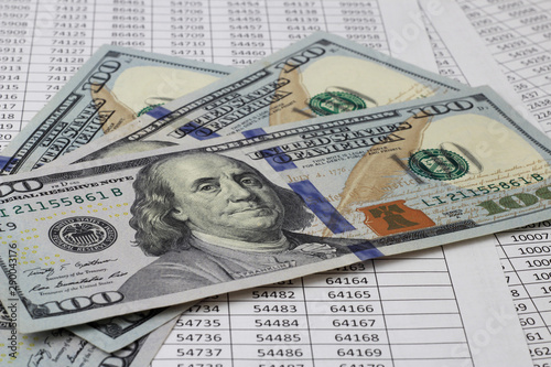 US dolar money for both financial and business concepts, lie on a table with tables of numbers. Banking, investments, deposits, save money.