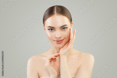 Beautiful woman looking at camera. Healthy spa model girl with clear skin. Skincare and facial treatment concept