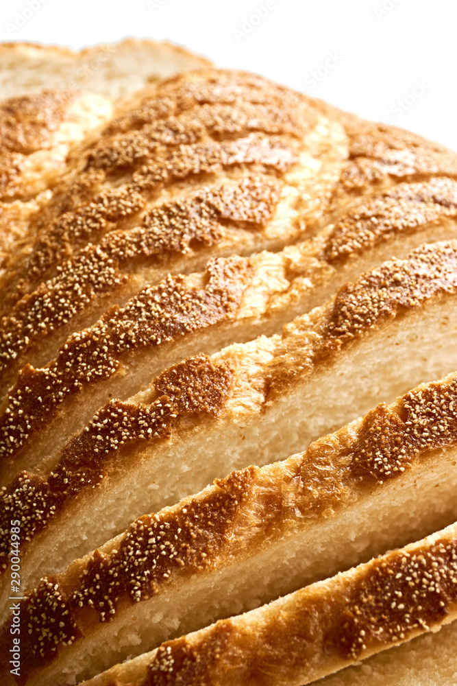 Slices of bread. Extreme closeup of freshly baked white sliced country bread with a crispy crust for use as a bakery background.. Vertical image an isolated on top for copy space. Slices of bread. Extreme closeup of freshly baked white sliced country bread with a crispy crust for use as a bakery background.. Vertical image an isolated on top for copy space.