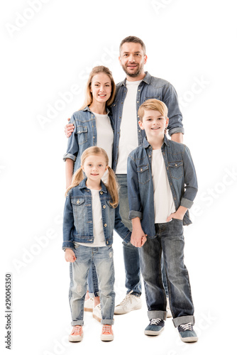 full length view of smiling family in jeans embracing and holding hands isolated on white