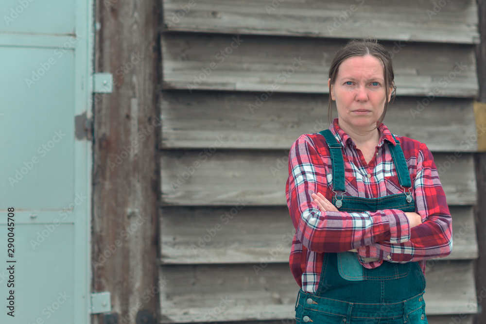 Portrait of female farmer in front of the farmhouse shed Portrait of female farmer in front of the farmhouse shed
