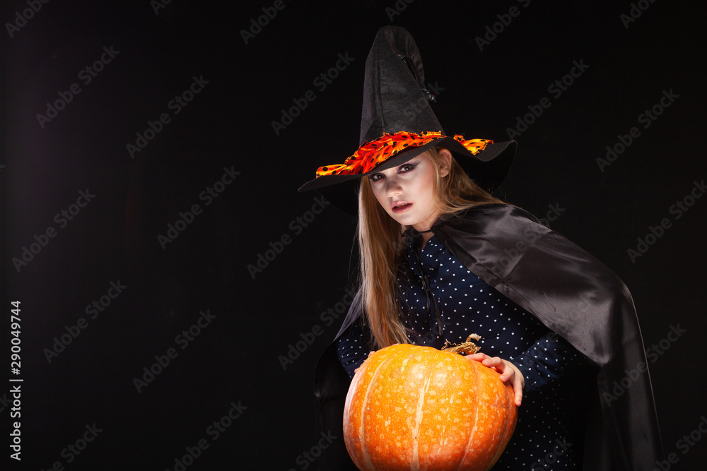 Halloween Witch with Pumpkin on black background. Beautiful young surprised woman in witches hat and costume holding pumpkin. Wide Halloween party art design. Copy-paste. Witch craft concept. Spider Halloween Witch with Pumpkin on black background. Beautiful young surprised woman in witches hat and costume holding pumpkin. Wide Halloween party art design. Copy-paste. Witch craft concept. Spider