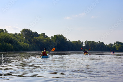 People in kayak and SUP paddling in Danube river at spring. Concept of active vacation