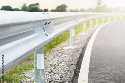 White reflective sign warn curve at night on the steel guard rail on the road in day time.