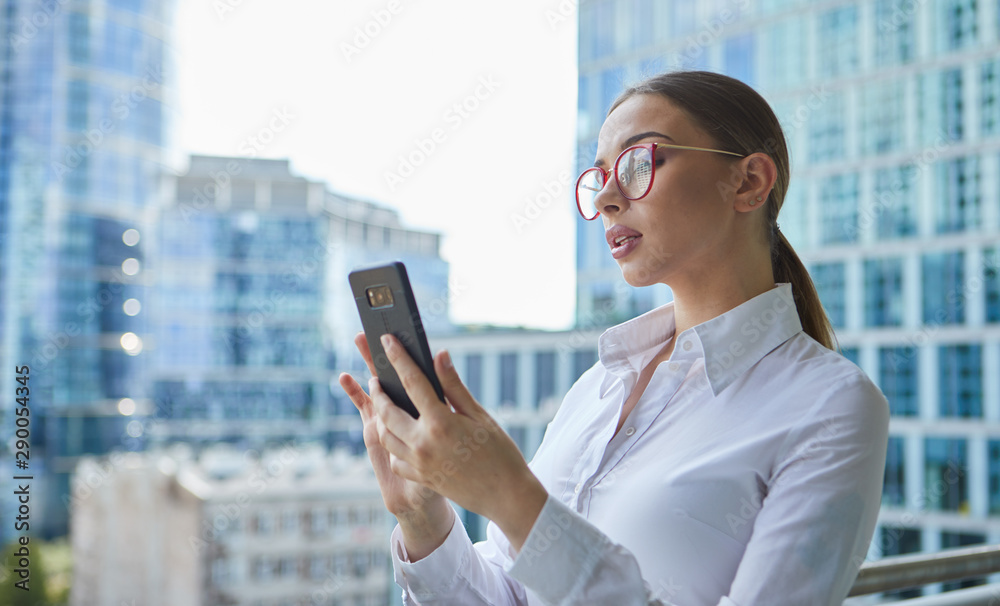 Beautiful business woman with smartphone on the background of the modern office