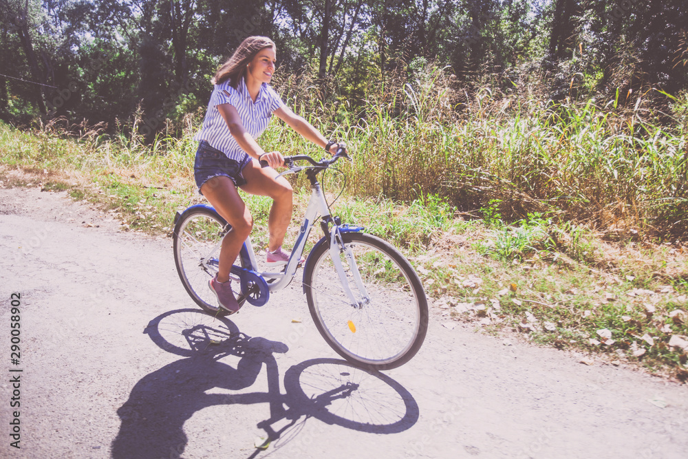 Pretty Young Woman Riding Bicycle In The Park