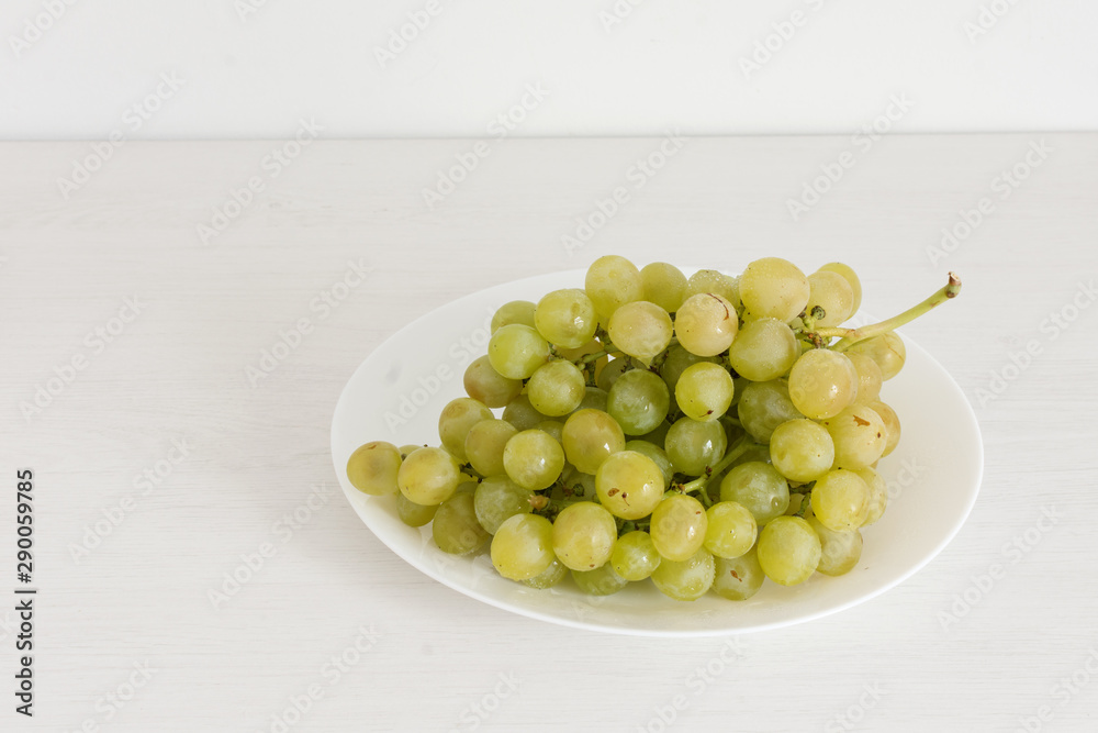Bunch of green grapes on white wooden background. Bunch of green grapes on white wooden background.