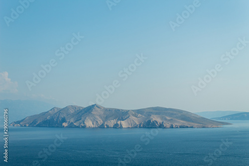 Seascape: rocky island, turquoise water, bright blue sky. Natural natural gradient of blue tones. Baska, island of Krk, Croatia.