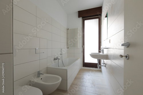 Modern renovated bathroom with large tiles and window