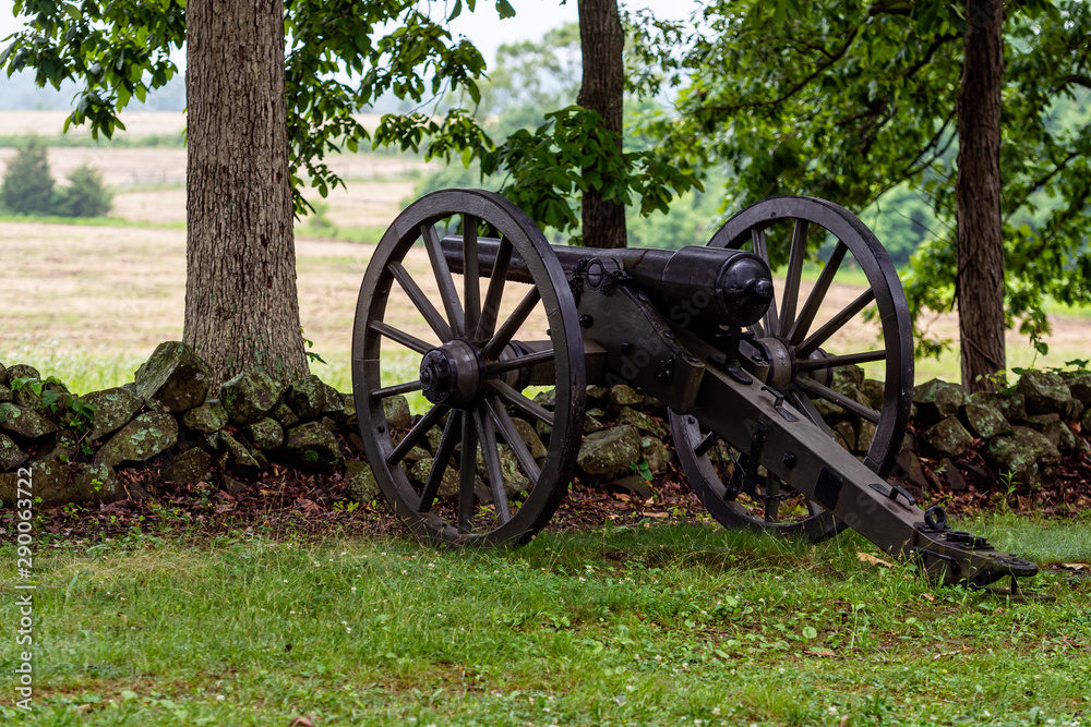 A Civil War era cannon is placed behind a stone wall in Gettysburg, PA - image