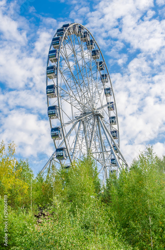 Ferris wheel against the blue sky with clouds