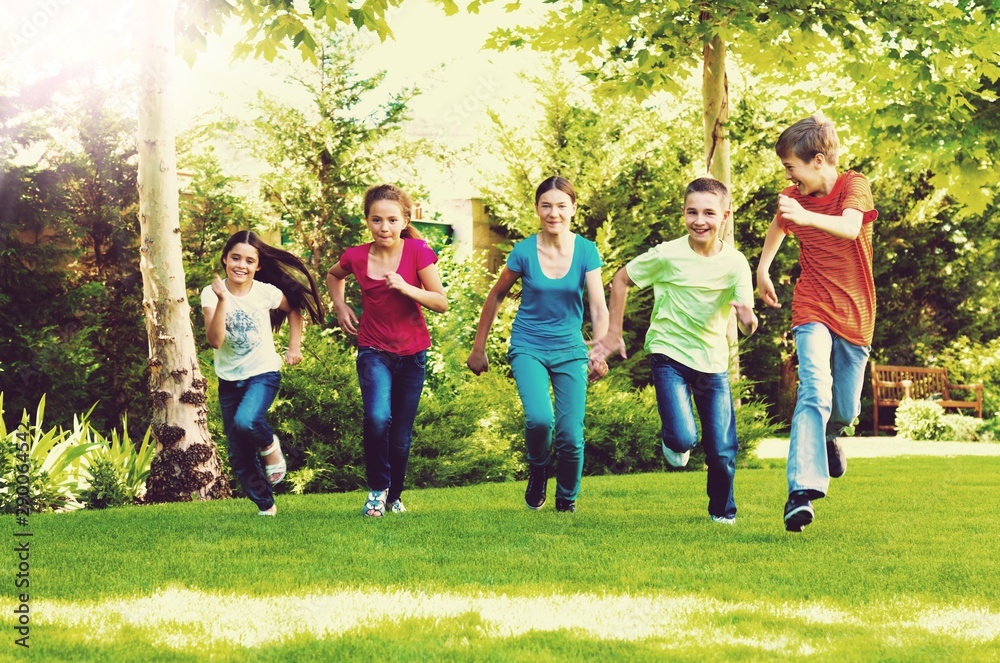 Happy  children running and playing in garden on sunny day - obrazy, fototapety, plakaty 