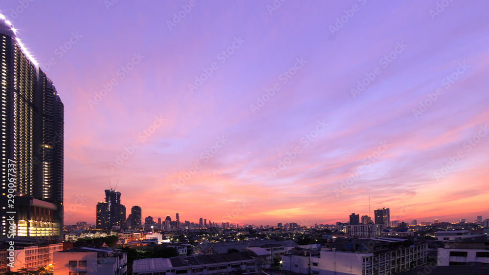 Obraz premium Panoramic cityscape skyline at twilight with modern skyscrapers under purple and pink sky background
