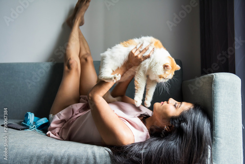 woman play with exotic shorthair cat on sofa