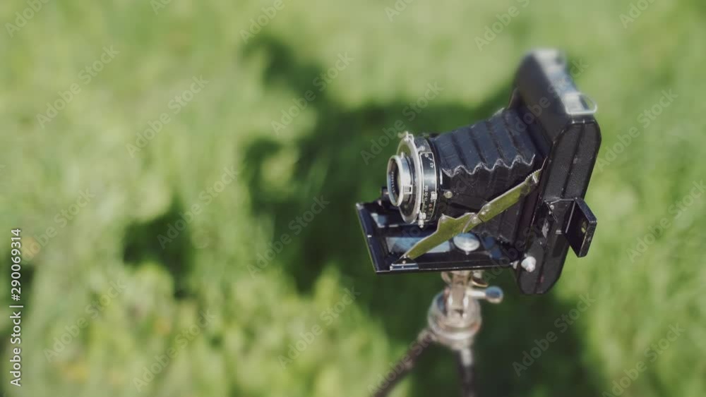 A person's shadow is conceptually posing behind an old vintage medium format photo camera. A person's shadow is conceptually posing behind an old vintage medium format photo camera.
