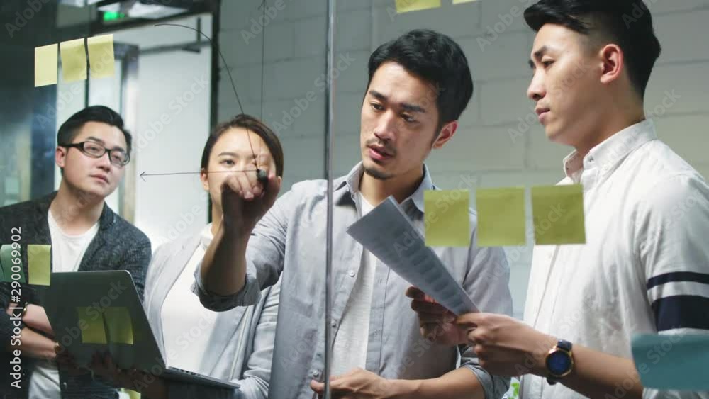 group of young asian entrepreneurs discussing business in company meeting room