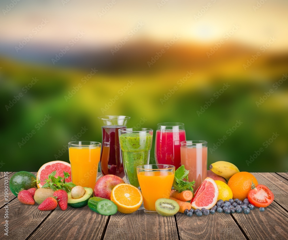 Tasty fruits  and juice with vitamins on background