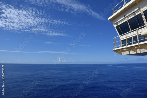 Calm ocean and a blue sky on a sunny day, view from sailing cargo ship.