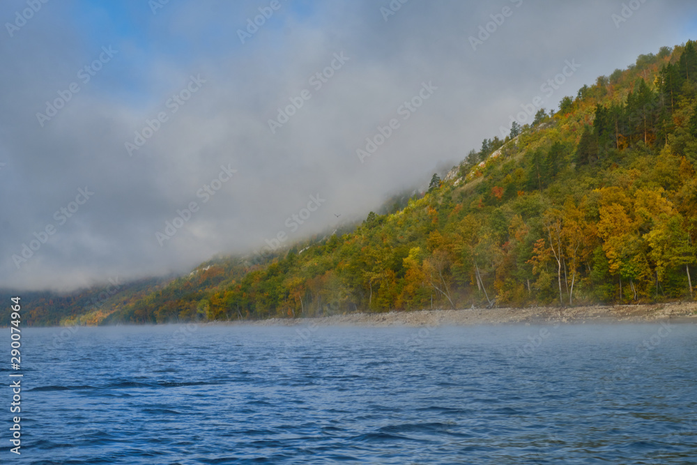 lake and mountains with autumn trees and fog. altai in autumn. yumaguzino