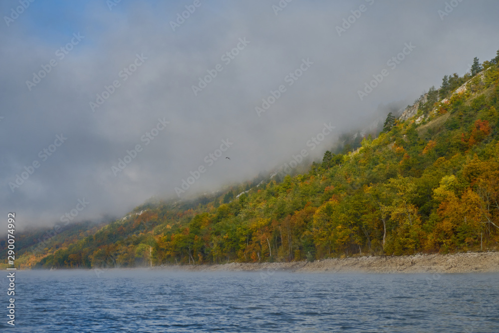lake and mountains with autumn trees and fog. altai in autumn. yumaguzino lake and mountains with autumn trees and fog. altai in autumn. yumaguzino