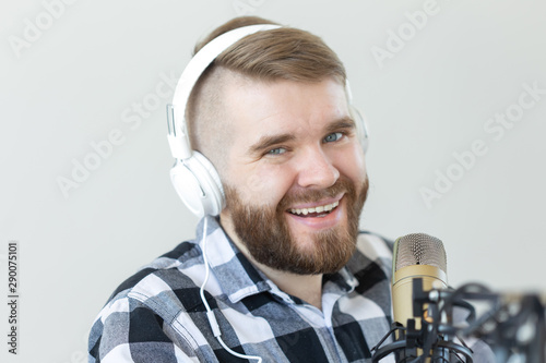 Radio and DJ concept - Man with microphone and big headphone is smiling