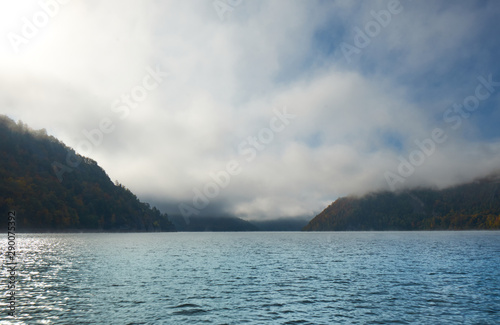 Lake in the midst of mountains and forests in fog. Altai nature