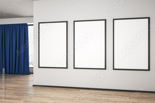 Blank white mock up posters on white wall in modern empty room with wooden floor and blue curtain.