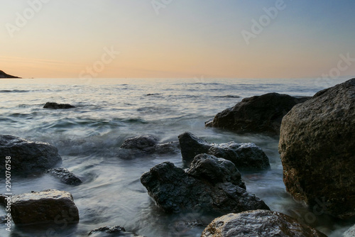 rocks in a sea with sunset. longer shutter