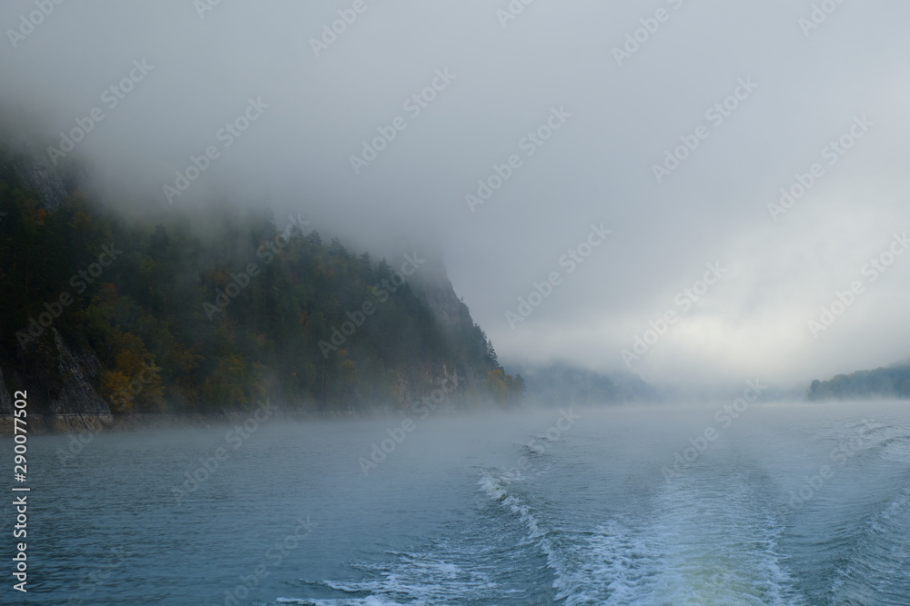 Walk on the Norwegian lake on a boat in the autumn in the fog. Wake of the boat Walk on the Norwegian lake on a boat in the autumn in the fog. Wake of the boat