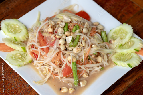 Green papaya salad or Som tum Thai in white plate, closeup. Thai cuisine, somtum salad popular food in Thailand