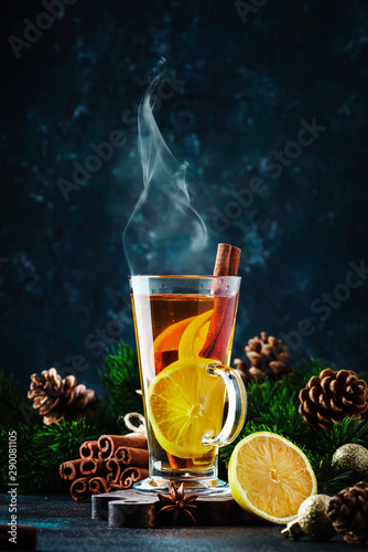 Christmas or New Year hot winter drink, spicy grog cocktail, sangria or mulled wine with tea, lemon, rum, cinnamon, anise. Rustic style, copy space photo