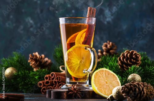 Christmas or New Year hot winter drink, spicy grog cocktail, sangria or mulled wine with tea, lemon, rum, cinnamon, anise. Rustic style, copy space photo