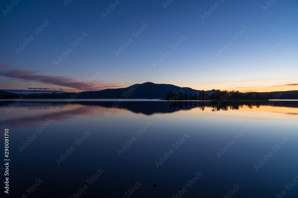 Tranquil dusk reflected in a lake in scandinavia. Ottsjon, Sweden.
