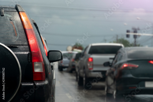Break of black car on asphalt roads during rainy time. Stop by traffic red light control. © thongchainak