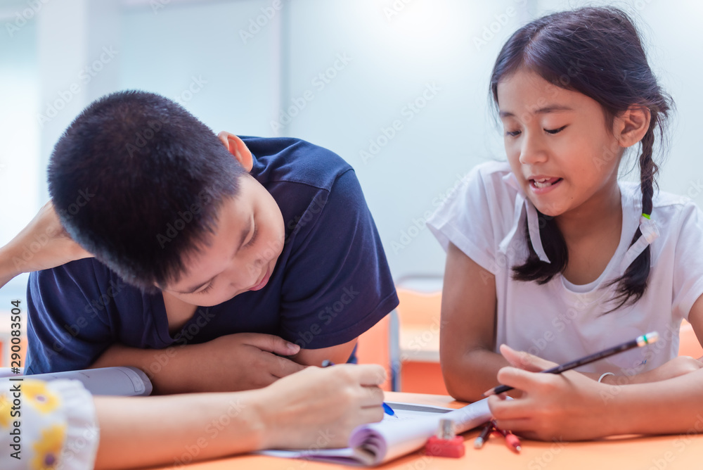 Asian elementary school girl and boy are studying and having fun in the classroom with female teachers. Asian elementary school girl and boy are studying and having fun in the classroom with female teachers.