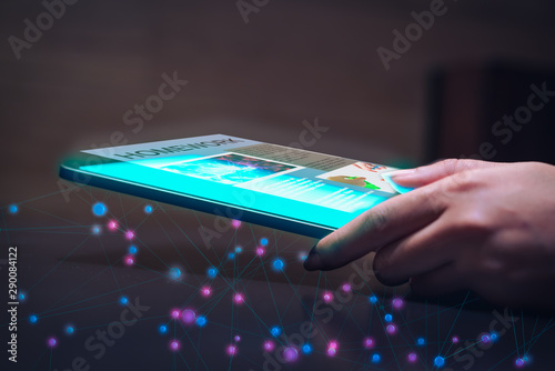 Female hand using tablet device for digital homework with hologram app - Futuristic classroom learning technology with touchscreen wireless holographic display - education, tech and 3D concept