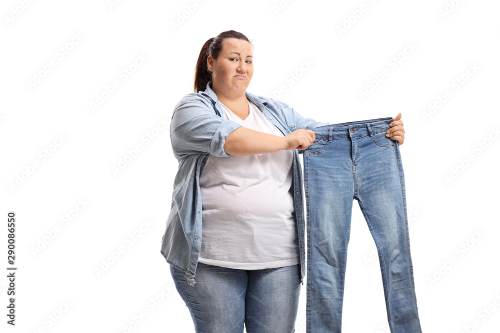 Sad overweight woman holding a pair of small jeans Stock Photo | Adobe Stock