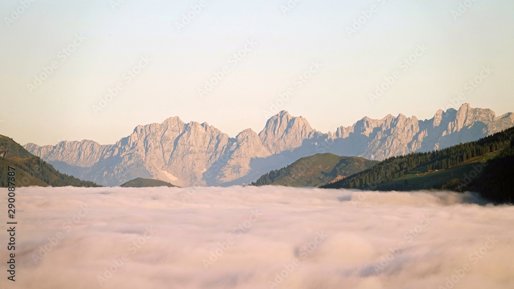 view to the wilder kaiser in tirol austria on a sunny morning with fog in the valley