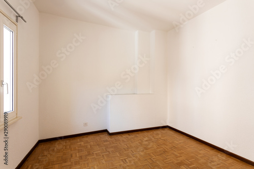 Empty room with all white walls and parquet floor